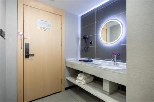 uma casa de banho com um lavatório e um espelho em Junyi Hotel Yongzhou Dao County Middle Xiaoshui Road 