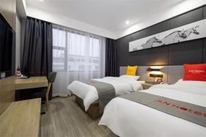 um quarto de hotel com duas camas e uma secretária em Junyi Hotel Yongzhou Dao County Middle Xiaoshui Road 