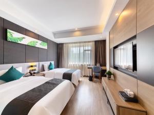 Habitación de hotel con 2 camas y escritorio en Thank Inn Plus Shijiazhuang Xinhua District West Beierhuan Road, en Shijiazhuang
