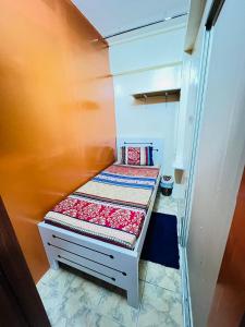 een kleine slaapkamer met een klein bed in een kamer bij Moon Backpackers , Al Rigga , Partition for Couples and for singles in Dubai