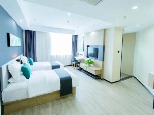 ウランホト市にあるThank Inn Plus Xing'an Senfa Four Season Flower Cityのベッドとテレビが備わるホテルルームです。