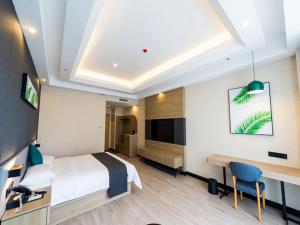 Habitación de hotel con cama, escritorio y TV. en Thank Inn Plus Datong Senyuan Building High-Speed Railway Station, en Datong