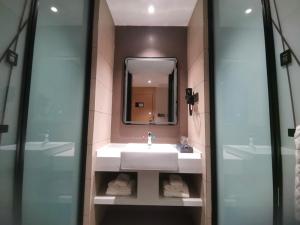 La salle de bains est pourvue d'un lavabo et d'un miroir. dans l'établissement Thank Inn Plus Chongqing Pengshui Yujing Jiangshan, à Pengshui