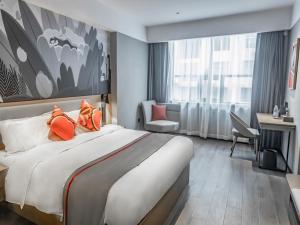Pokój hotelowy z dużym łóżkiem z pomarańczowymi poduszkami w obiekcie Thank Inn Hengyang Leiyang City Jinhua Road w mieście Leiyang