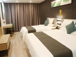 日喀則的住宿－尚客优品日喀则扎什伦布寺酒店，酒店客房配有两张床和一张书桌