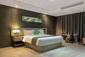 a bedroom with a large bed and a desk and chair at Thank Inn Plus Suqian Shuyang Shandong Mall in Suqian