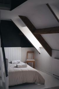1 dormitorio con 1 cama y techo con vigas. en La villa des Crénées, en Héron
