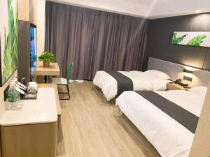 a hotel room with two beds and a desk at Thank Inn Plus Yinchuan Dayue City in Yinchuan