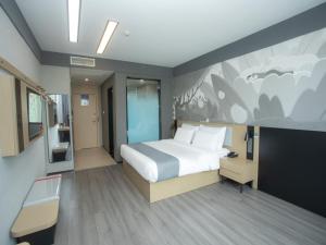a bedroom with a bed and a painting on the wall at Thank Inn Hotel Changsha Ningxiang Avenue High-Speed Railway Station in Ningxiang