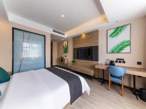a bedroom with a bed and a desk and a television at Thank Inn Plus Shijiazhuang Xinhua District West Beierhuan Road in Shijiazhuang