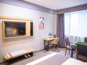 a hotel room with a bed and a flat screen tv at Thank Inn Hotel Changsha Ningxiang Avenue High-Speed Railway Station in Ningxiang