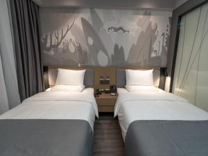 蘭州市にあるThank Inn Plus Lanzhou New District Zhongchuan Airport Rainbow Cityのベッド2台が隣同士に設置された部屋です。