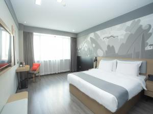 a bedroom with a large bed and a painting on the wall at Thank Inn Hotel Changsha Ningxiang Avenue High-Speed Railway Station in Ningxiang