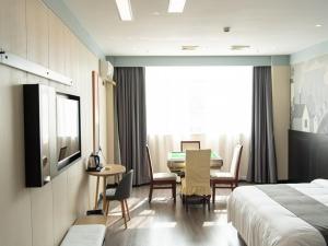 Habitación de hotel con cama, mesa y sillas en Thank Inn Plus Nanchang Longhu Paradise Street, en Nanchang