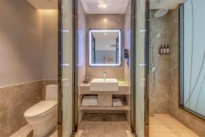 uma casa de banho com um lavatório, um WC e um chuveiro em Thank Inn Plus Ordos Qipanjing Government Affairs Service Center em Shizuishan