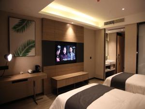 銀川市にあるThank Inn Plus Yinchuan Dayue Cityのベッド1台、薄型テレビが備わるホテルルームです。