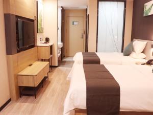 日喀則的住宿－尚客优品日喀则扎什伦布寺酒店，酒店客房设有两张床和电视。