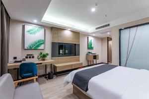 a bedroom with a bed and a desk and a tv at Thank Inn Plus Shijiazhuang Xinhua District West Beierhuan Road in Shijiazhuang