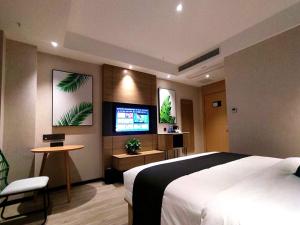 Schlafzimmer mit einem Bett und einem Flachbild-TV in der Unterkunft Thank Inn Plus Chongqing Pengshui Yujing Jiangshan in Pengshui