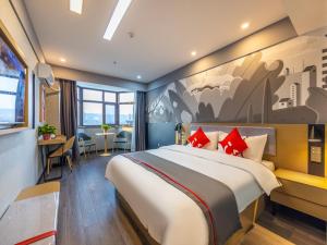 una habitación de hotel con una cama grande con almohadas rojas en Thank Inn Plus Linxia Bafang Shisanxiang, en Linxia