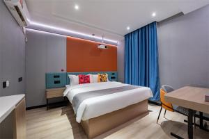a bedroom with a large bed and a desk and a table at Junyi Hotel Wuhan Liuduqiao Subway Station in Wuhan