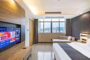 a hotel room with a bed and a flat screen tv at Thank Inn Plus Shaoguan Qujiang District Maba in Shaoguan