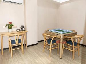 um quarto com duas mesas e duas cadeiras e uma mesa em Thank Inn Plus Dongguan Dalingshan em Dongguan