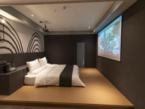 蘭州市にあるThank Inn Plus Lanzhou New District Zhongchuan Airport Rainbow Cityのベッドルーム1室(ベッド1台、壁掛けテレビ付)
