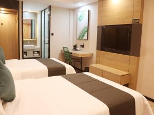 日喀則的住宿－尚客优品日喀则扎什伦布寺酒店，酒店客房设有两张床和一台平面电视。