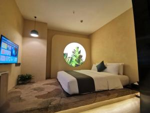 - une chambre avec un grand lit et une télévision dans l'établissement Thank Inn Plus Chongqing Pengshui Yujing Jiangshan, à Pengshui