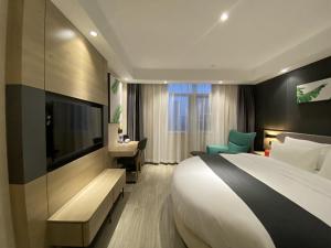 um quarto de hotel com uma cama grande e uma televisão em Thank Inn Plus Yancheng Sheyang Dayang Road em Sheyang
