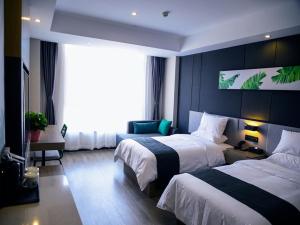 a hotel room with two beds and a large window at Thank Inn Plus Yinchuan Dayue City in Yinchuan