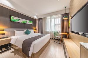 TaizhouにあるThank Inn Plus Taizhou Jingyan District Yameiのベッド1台、薄型テレビが備わるホテルルームです。