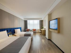 een hotelkamer met 2 bedden en een flatscreen-tv bij LanOu Hotel Taikoo Li Night Market Kuqa City in Kuqa
