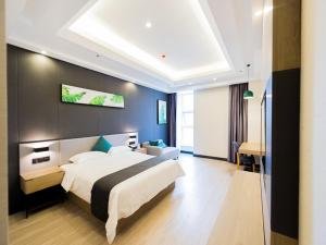 1 dormitorio con 1 cama grande y pared azul en Thank Inn Plus Datong Senyuan Building High-Speed Railway Station, en Datong