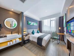 um quarto de hotel com uma cama, um lavatório e uma banheira em Thank Inn Plus Dongguan Dalingshan em Dongguan