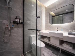 een badkamer met een douche, een toilet en een wastafel bij Thank Inn Plus Zhuji High-Speed Railway Statio Wangyun Road in Zhuji
