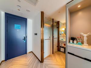 einen Flur mit blauer Tür in einem Zimmer in der Unterkunft LanOu Hotel Fuzhou Changle District Changle Airport in Fuzhou