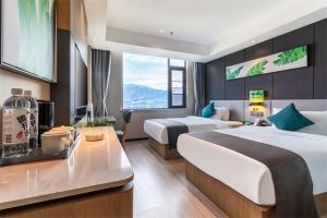 ラサ市にあるThank Inn Plus Tibet Lhasa East Dangre Roadのベッド2台とテーブルが備わるホテルルームです。