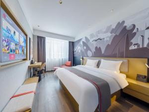 a hotel room with a large bed and a tv at Thank Inn Linyi Jiaxing Fruit Market in Linyi