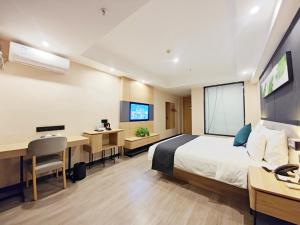 a hotel room with a bed and a desk with a computer at Thank Inn Plus Lanzhou Dongfanghong Plaza Pingliang Road in Lanzhou +39 photos