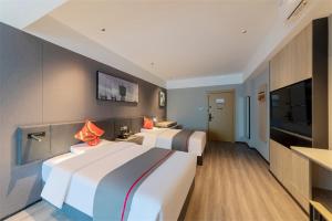 a hotel room with two beds and a flat screen tv at Thank Inn Shaoxing Luxun Hometown in Shaoxing