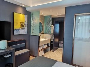 LanOu Hotel Longjiang Road Shigatse في شيغاتسي: غرفة بسرير وحمام مع حوض