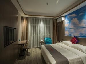 a hotel room with a large bed and a desk at Junyi Hotel Jizhou District East Yangming Road in Ji'an