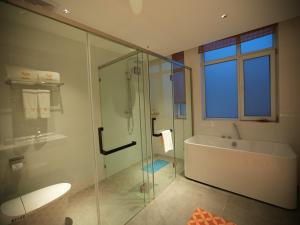 a bathroom with a glass shower and a tub and a sink at Feronia Hotel Taihang Xiyagou Tourist Area in Nanhekou