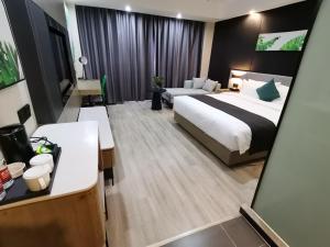 una grande camera d'albergo con un letto e un divano di Thank Inn Plus Aksu Kuqa Xingfu Road a Kuqa