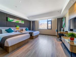 um quarto de hotel com duas camas e uma secretária em Thank Inn Plus Tibet Lhasa East Dangre Road em Lhasa
