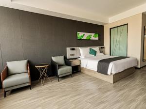 een hotelkamer met een bed en twee stoelen bij Thank Inn Plus Xuzhou Yunchuang Technology Park Ocean Polar World in Xuzhou