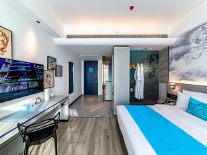 um quarto de hotel com uma cama grande e uma secretária em LanOu Hotel Fuzhou Changle District Changle Airport em Fuzhou
