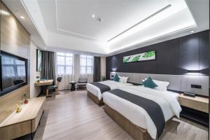 ein Hotelzimmer mit 2 Betten und einem TV in der Unterkunft Thank Inn Plus Chaozhou Caitang Lotus in Xialian